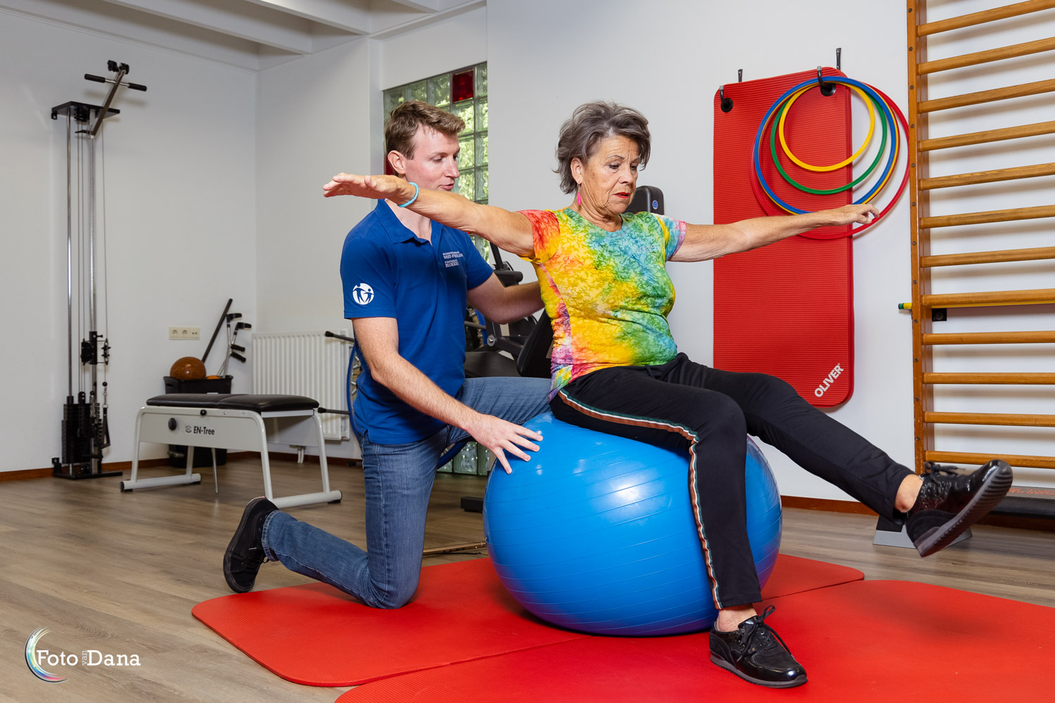 vrouw op blauwe bal oefening fysiotherapeut