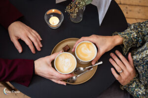 twee paar handen bij twee kopjes koffie