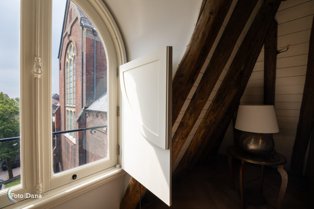 Raam van een slaapkamer met uitzicht op de Grote Kerk in Hoorn.